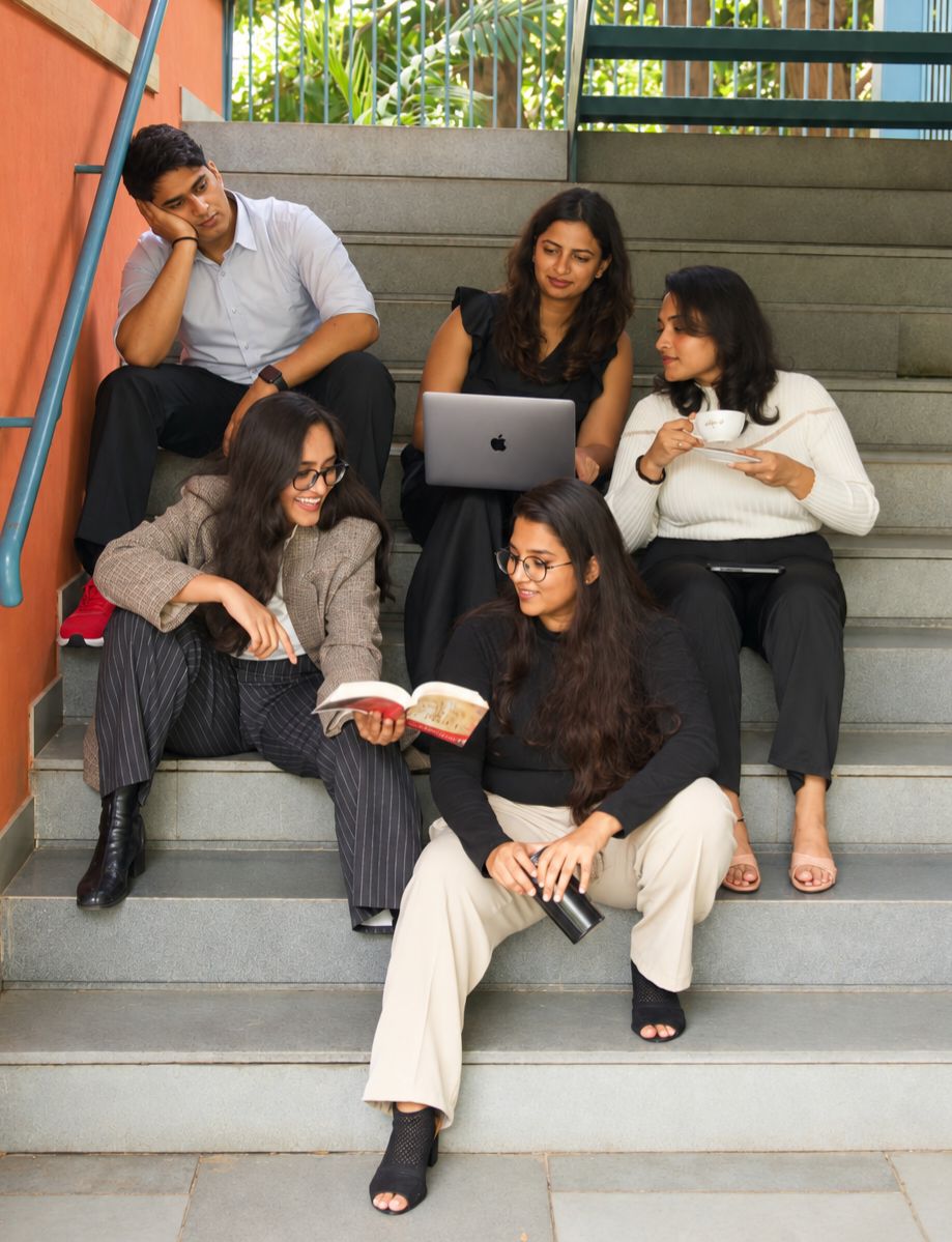 Five Tangent & Curve team members sitting together on steps